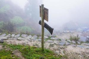 waymark on mountain path in misty spring day photo