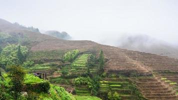view of hills with terraced rice fields in rain photo