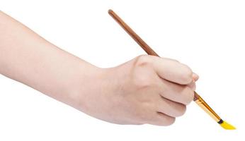 hand holds artistic paint brush with yellow tip photo