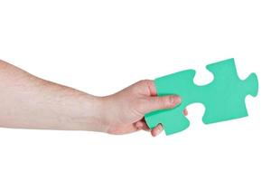 male hand holding big green paper puzzle piece photo