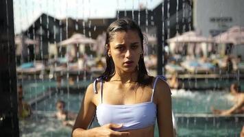 jong vrouw in zwempak nemen douche Bij water park video