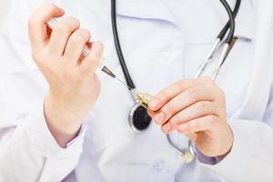 nurse fills syringe from vial photo