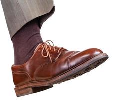 male right foot in brown shoe takes a step photo