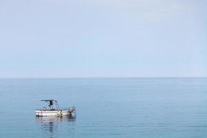 boat in Ionian sea in blue evening twilight photo