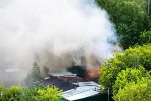 wet roofs, burning garage and white smoke photo