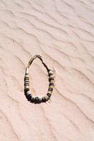 beads on red sand dune in desert photo