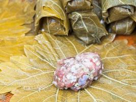 cooking of dolma from vine leaves, mince and rice photo