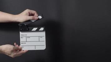 Movie slate or clapperboard hitting. Close up hand holding video