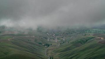 Puente de 8k en la autopista interurbana en el valle bajo nubes de tormenta video