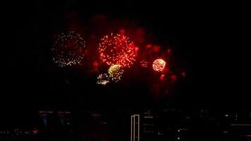 lindos fogos de artifício festivos no céu noturno sobre a cidade. férias na cidade. lançamento de fogos de artifício em homenagem ao evento video