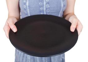 mujer sostiene plato negro vacío foto