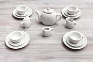 tazas con platillos y juego de té en la mesa marrón gris foto