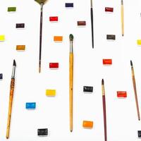 side view paint brushes and watercolors on white photo