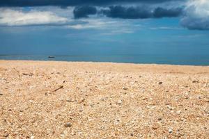 scenery with sand beach and dark blue rain clouds photo