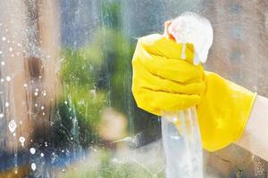 hand washes home window from spray bottle photo