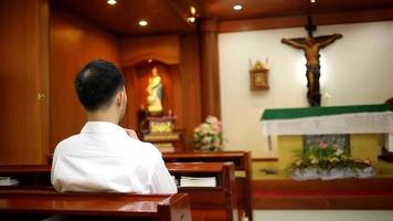 Aziatisch Mens baard vervelend waarmee overhemd christen bidden bidden naar god terwijl zittend in de kerk. video