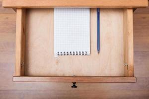 blue pen and squared notebook in open drawer photo