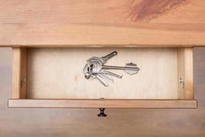 bunch of door keys on ring in open drawer photo