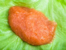 handful of salty caviar of carp on green leaf photo