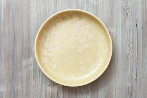 top view of green plate on gray brown table photo