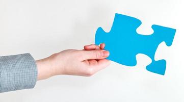 blue puzzle piece in female hand photo