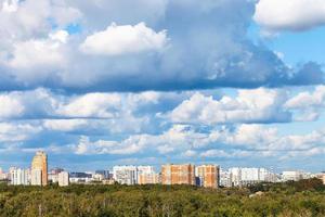 nubes azules bajas sobre el bosque verde y la ciudad foto