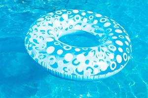 círculo de natación inflable en piscina azul al aire libre foto