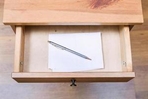 folded note and pen in open drawer photo