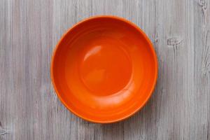 above view of orange bowl on gray brown table photo