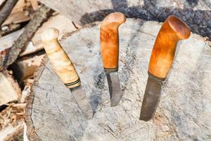 hunting knives thrust in tree stump photo