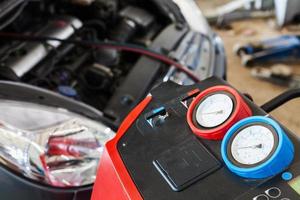 refueling of car conditioner in auto repair shop photo