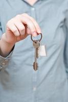 bunch of door keys with key ring in hand photo