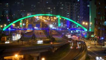 Luces nocturnas brillantes de 8k y tráfico de vehículos en el centro de la ciudad llena de gente video