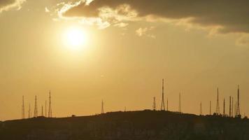 8k pôr do sol atrás de torres de antenas altas video