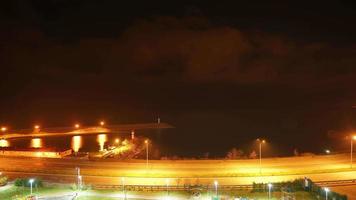 Carretera de 8k y luces del puerto junto al mar por la noche video