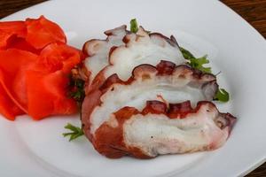 Octopus sashimi on the plate and wooden background photo