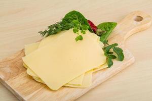 Sliced sheese on wooden board and wooden background photo