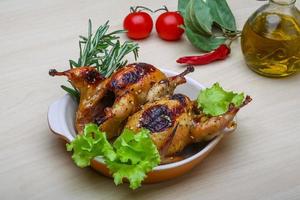 Roasted Quail on the plate and wooden background photo