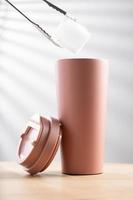 Pastel pink stainless steel tumbler size 20 ounce on wooden table