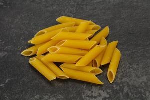 Raw penne pasta for bowl photo