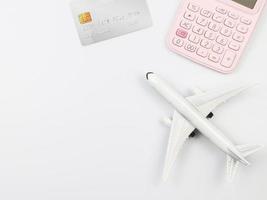 flat lay of airplane model, pink calculator and credit card,  preparation for traveling concept. photo