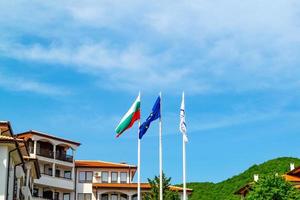 Flag of Bulgaria and European Union waving with the wind above villas photo
