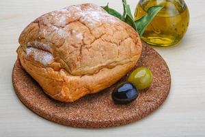 Ciabatta bread on wooden board and wooden background photo