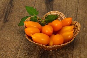 montón de tomate amarillo en el cuenco de madera foto