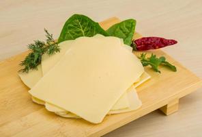 Sliced sheese on wooden board and wooden background photo