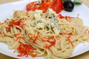 Cheese pasta on the plate and wooden background photo