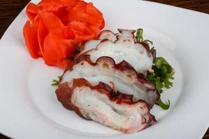 Octopus sashimi on the plate and wooden background photo