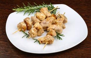 Chicken skewers on the plate and wooden background photo