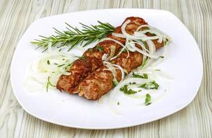 Kebab on the plate and wooden background photo