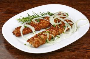 Beef kebab on the plate and wooden background photo